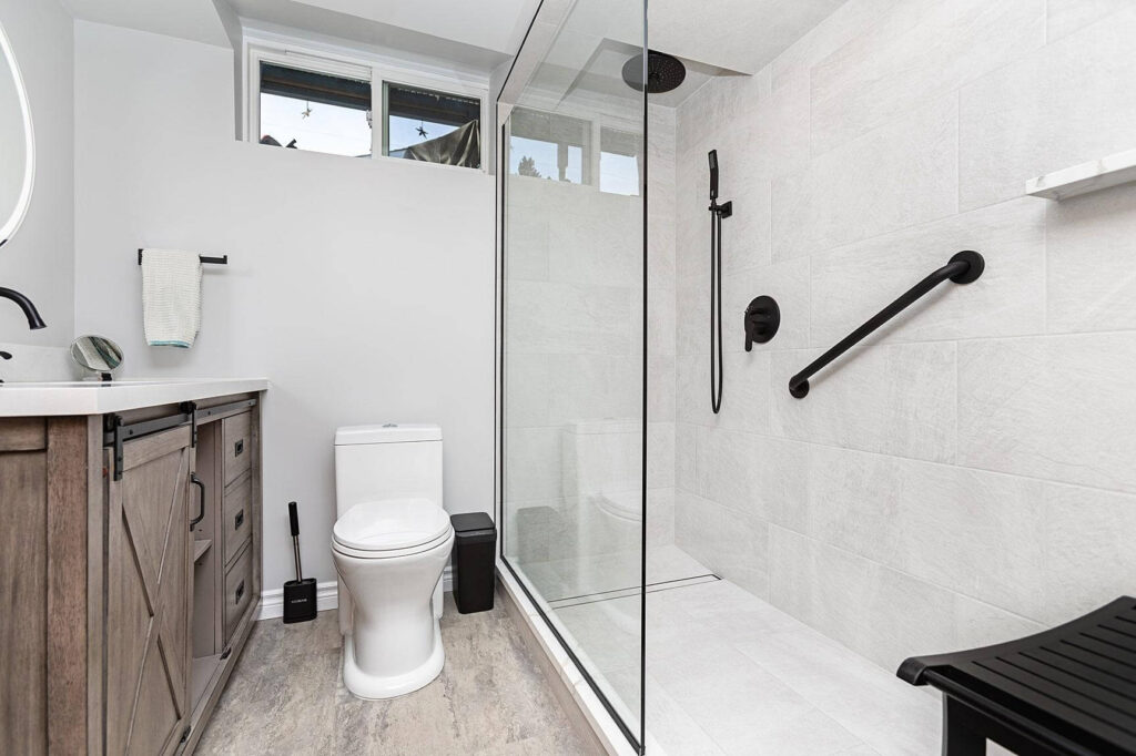 renovated bathroom with walk in shower with safety bars