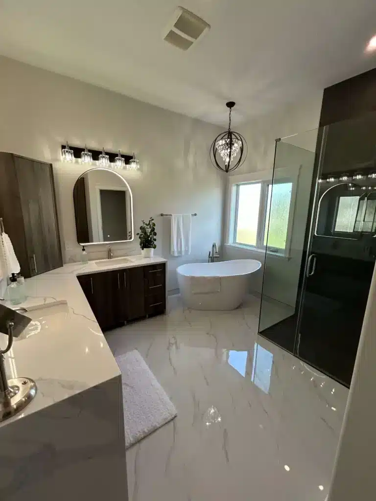 after image of greater edmonton bathroom renovation with freestanding soaker tub and new floor tiling and marble counter.