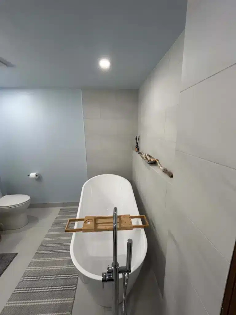 bathroom with freestanding soaker tub after bathroom renovation where a doorway was closed in